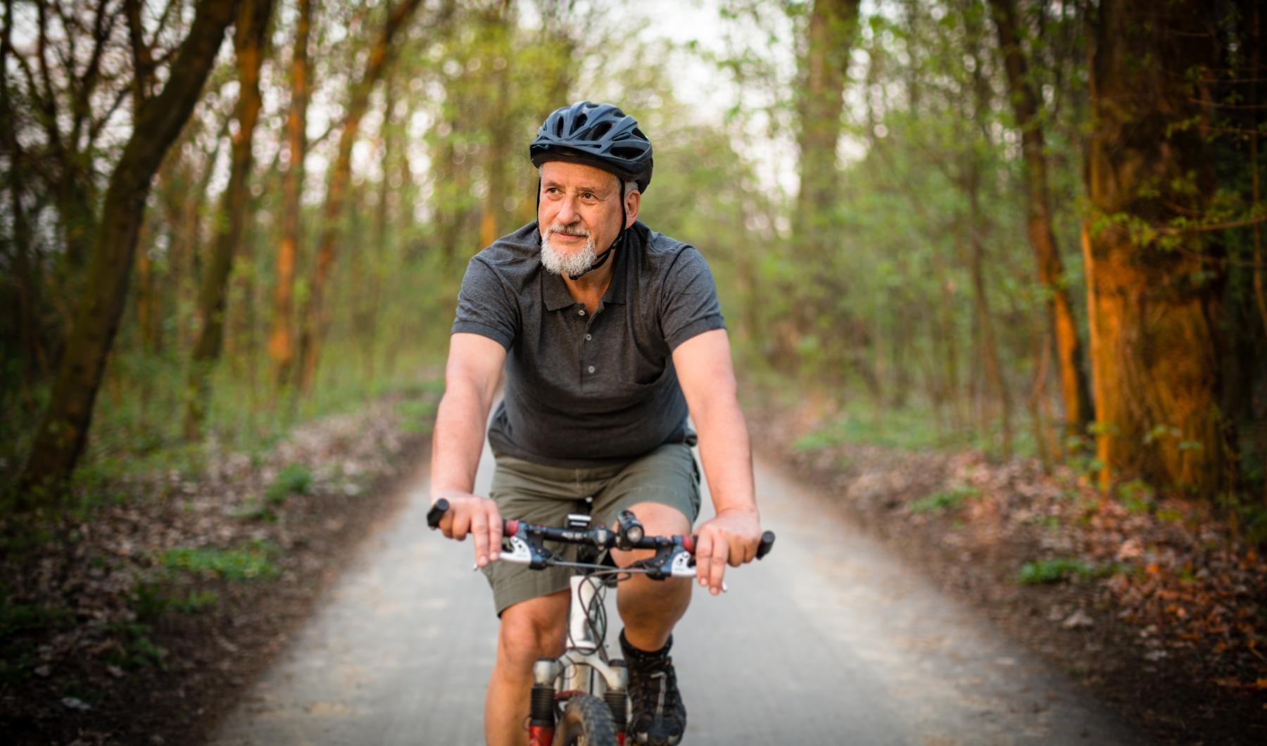 a man riding a bicycle on a trail in the woods