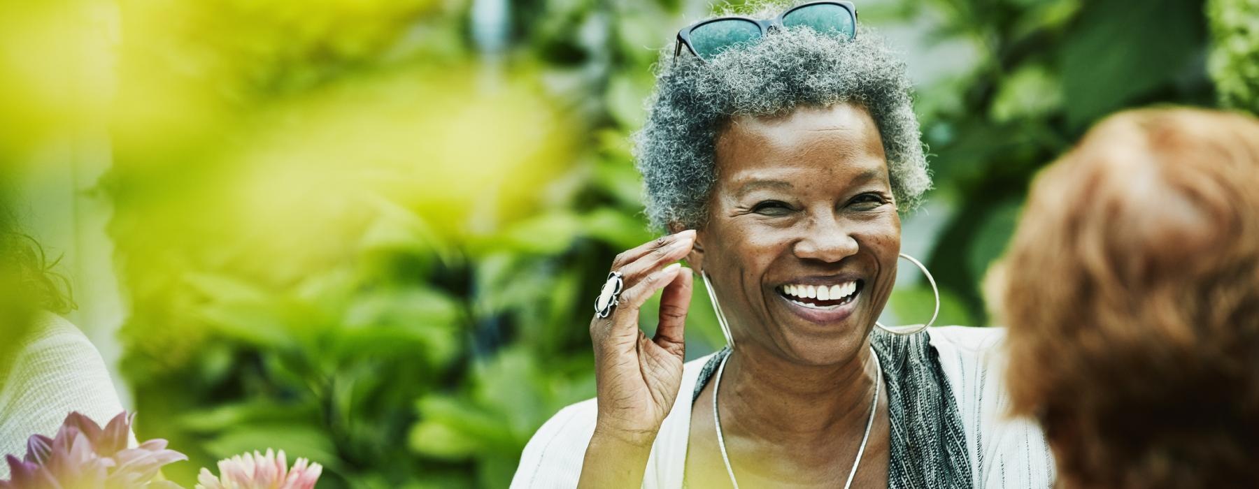 a person smiling with flowers in the back