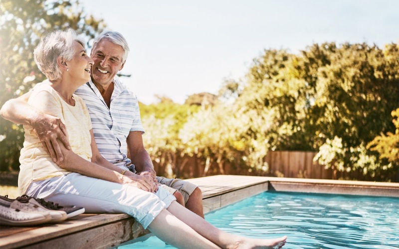 a man and woman sitting by a pool
